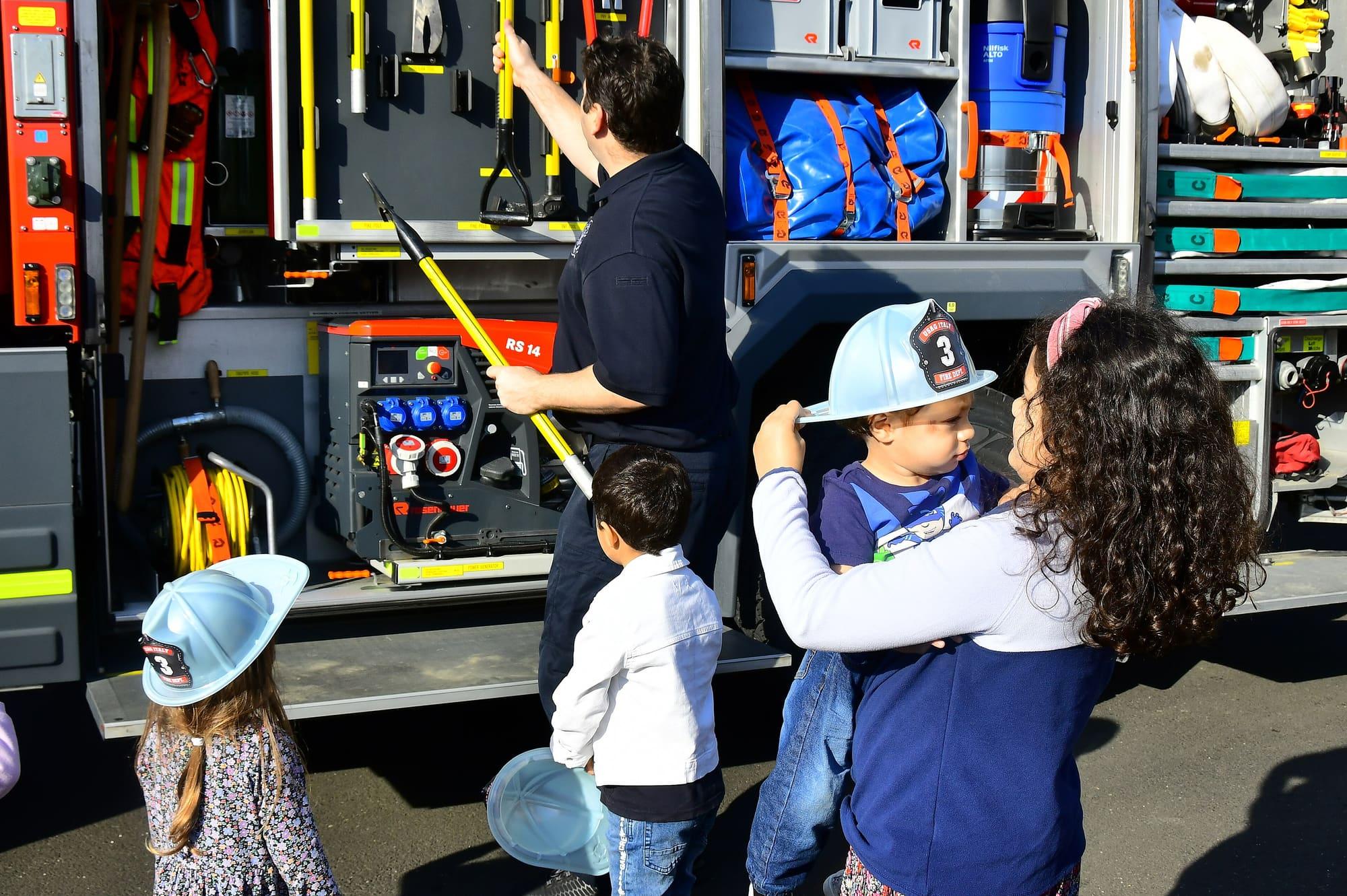 firefighters showing children a fire engine